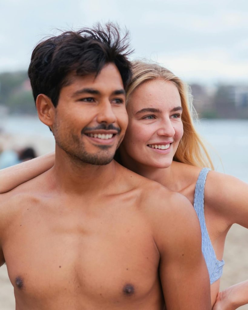 Smiling couple by the ocean after a surf session in Santa Teresa